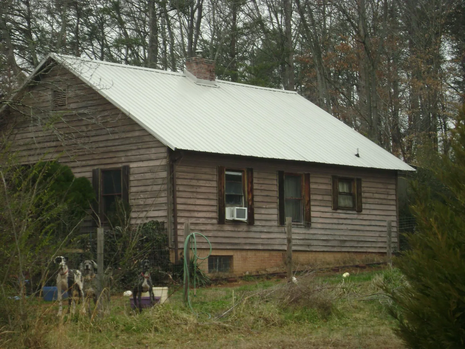 White metal roof on an old wood sided farmhouse, from a Asphalt Shingle Roof Repair job in Pinson